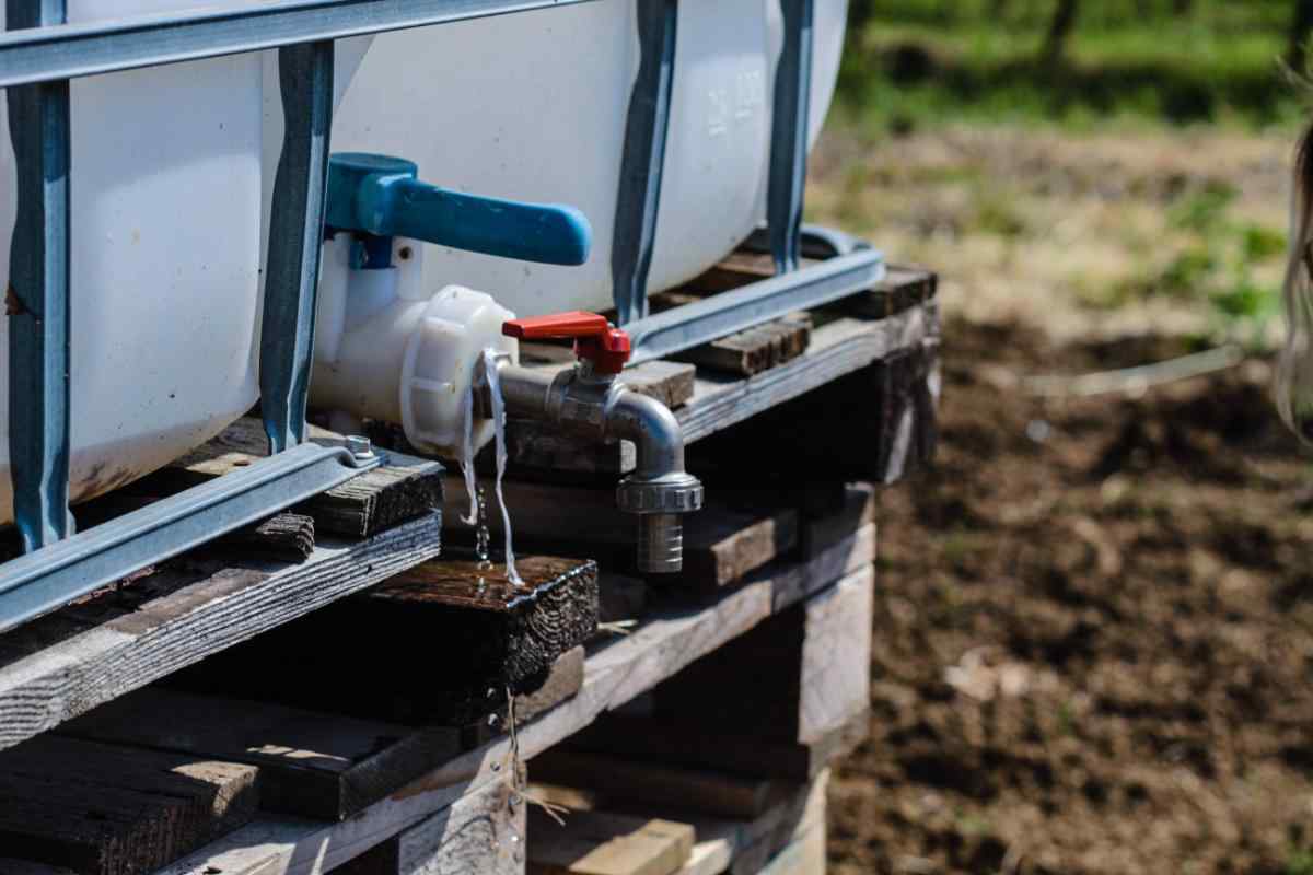 Rimozione di un vecchio adattatore improvvisato dalla valvola di una cisterna IBC prima di montare il raccordo TechOrto.